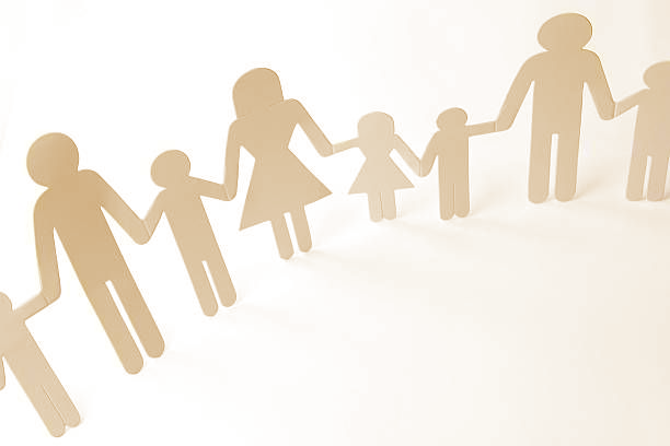 Chain of paper cutout figures holding hands.