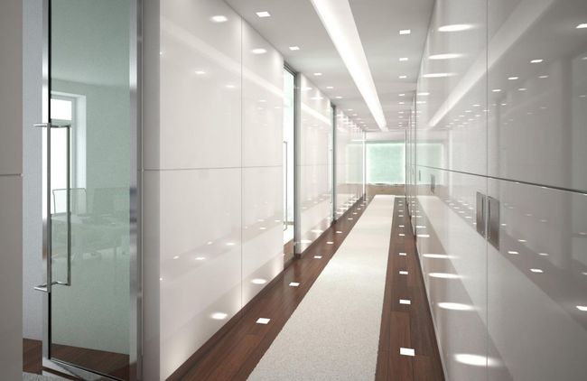 Couloir de bureau moderne avec parois vitrées, panneaux blancs et long parquet éclairé par une lumière vive