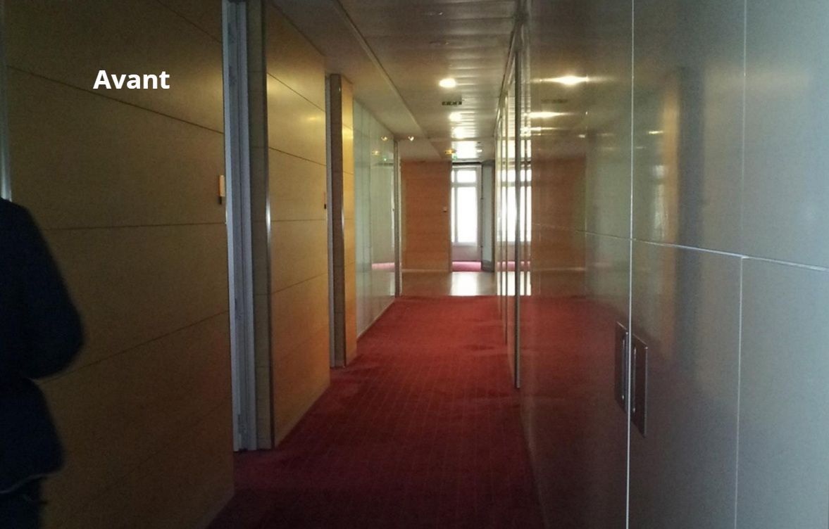 Un couloir avec un tapis rouge et un panneau indiquant avant