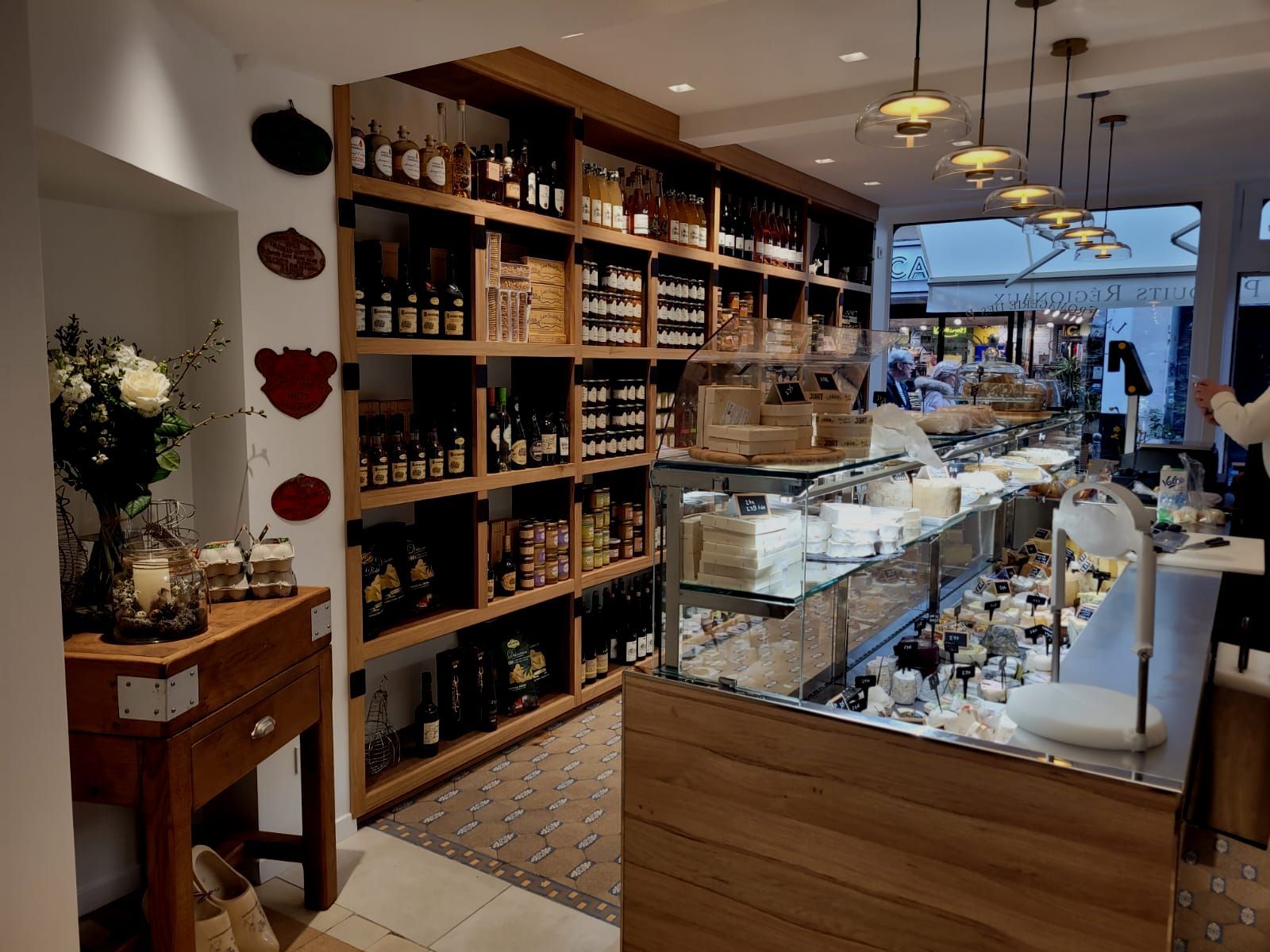 Un magasin rempli de nombreuses étagères et d'un comptoir réalisé par mes services d'architecte d'intérieur à Pont l'Eveque