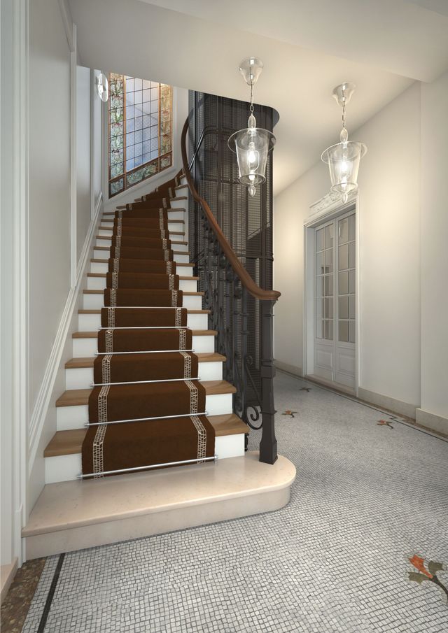 Élégant escalier avec rampe en bois foncé dans un hall d'entrée lumineux avec sol carrelé à motifs et lustres en verre.
