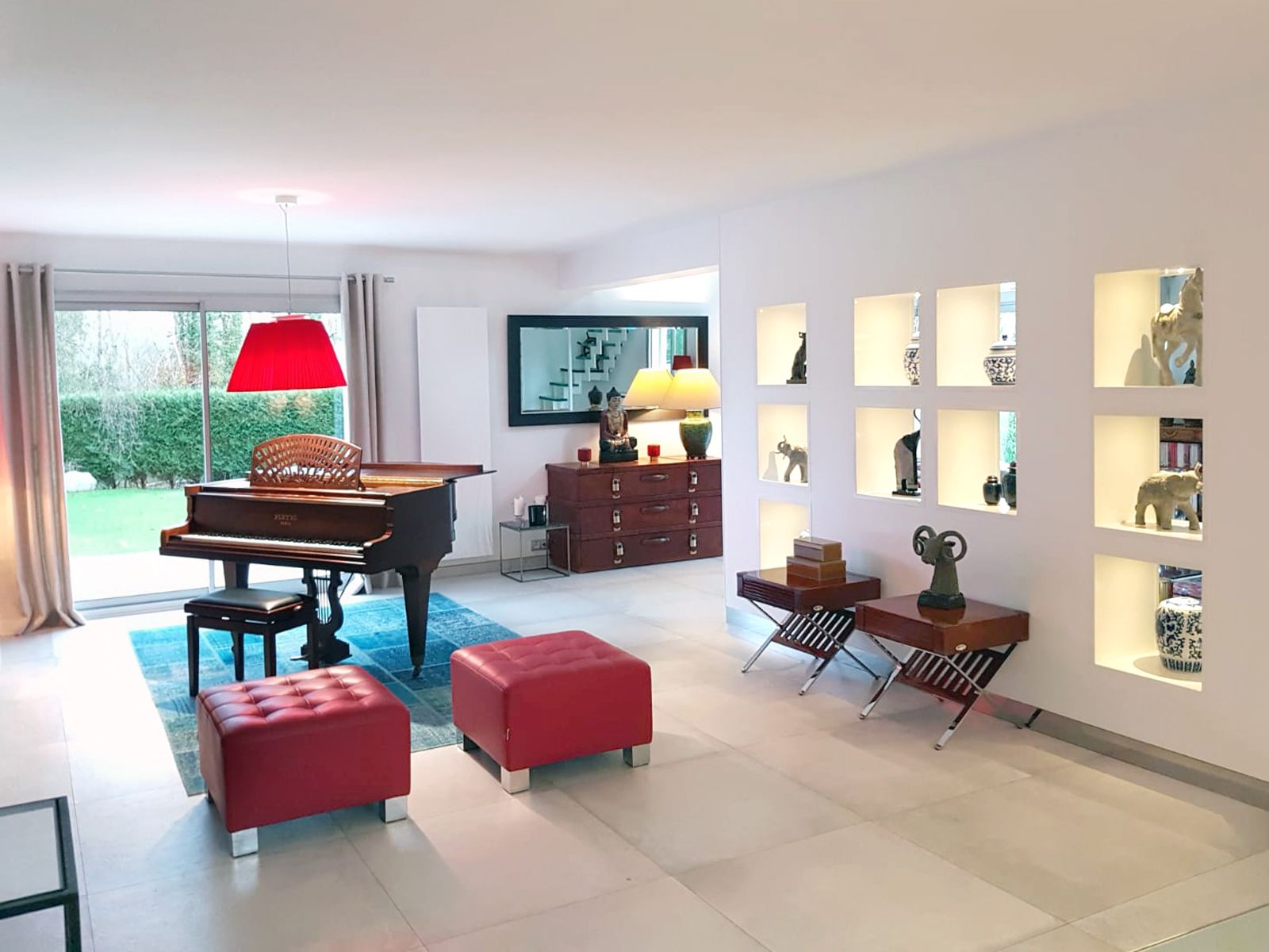 Un salon avec un piano et des fauteuils rouges à Pont l'Eveque