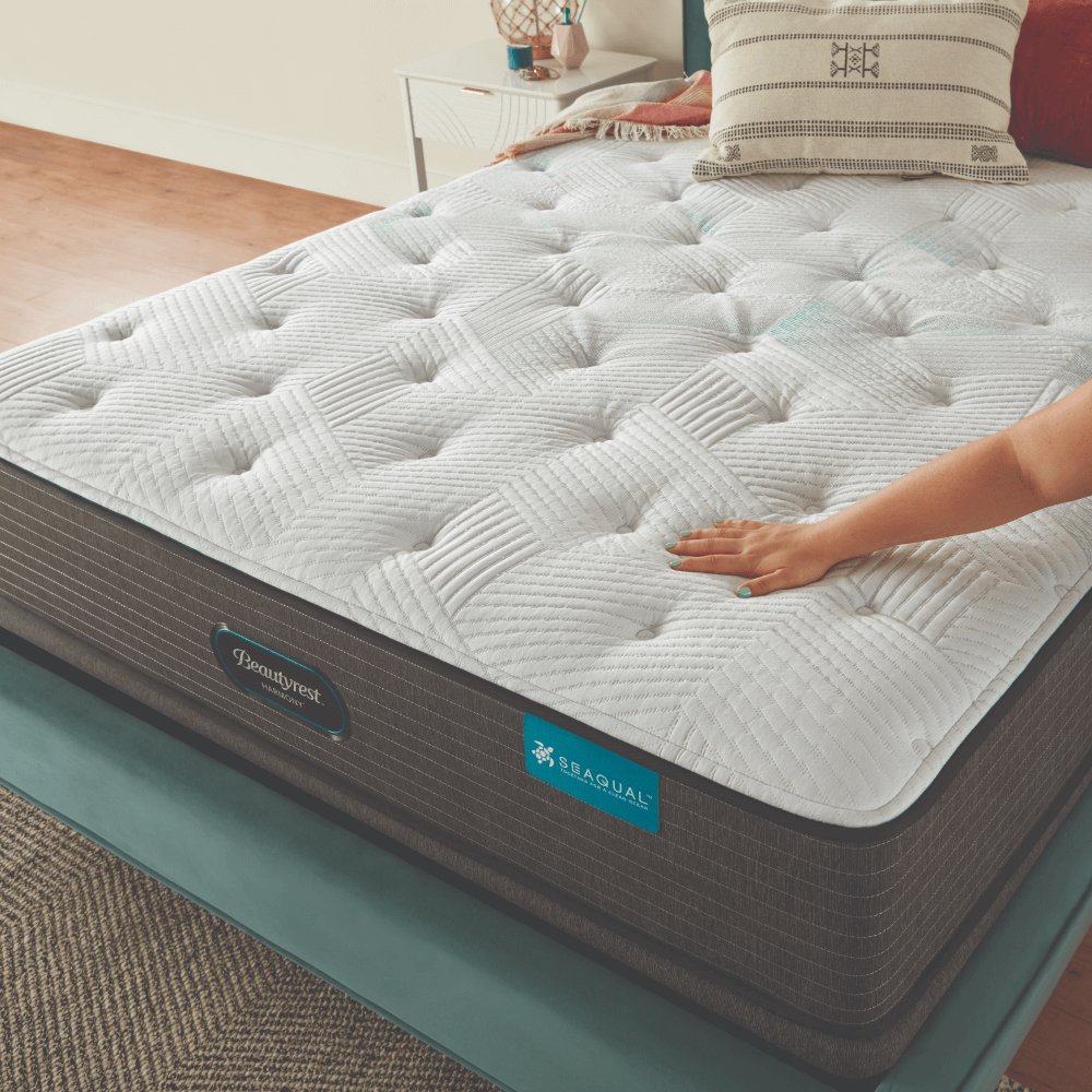 Una persona toca el colchón de una cama.