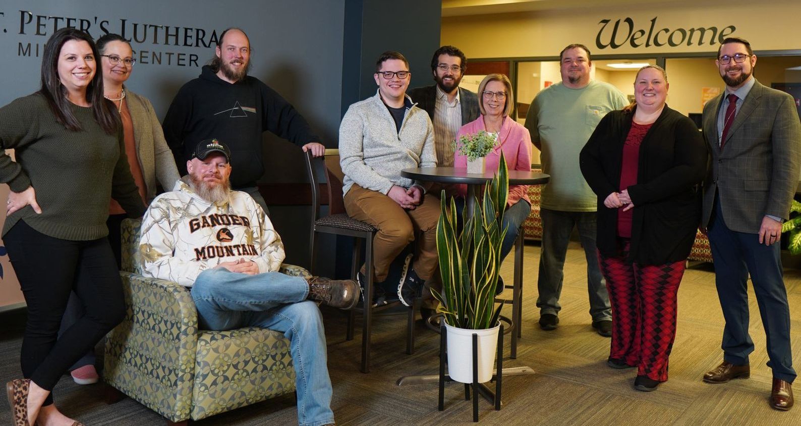 Group of people in a building lobby; some seated, some standing. 