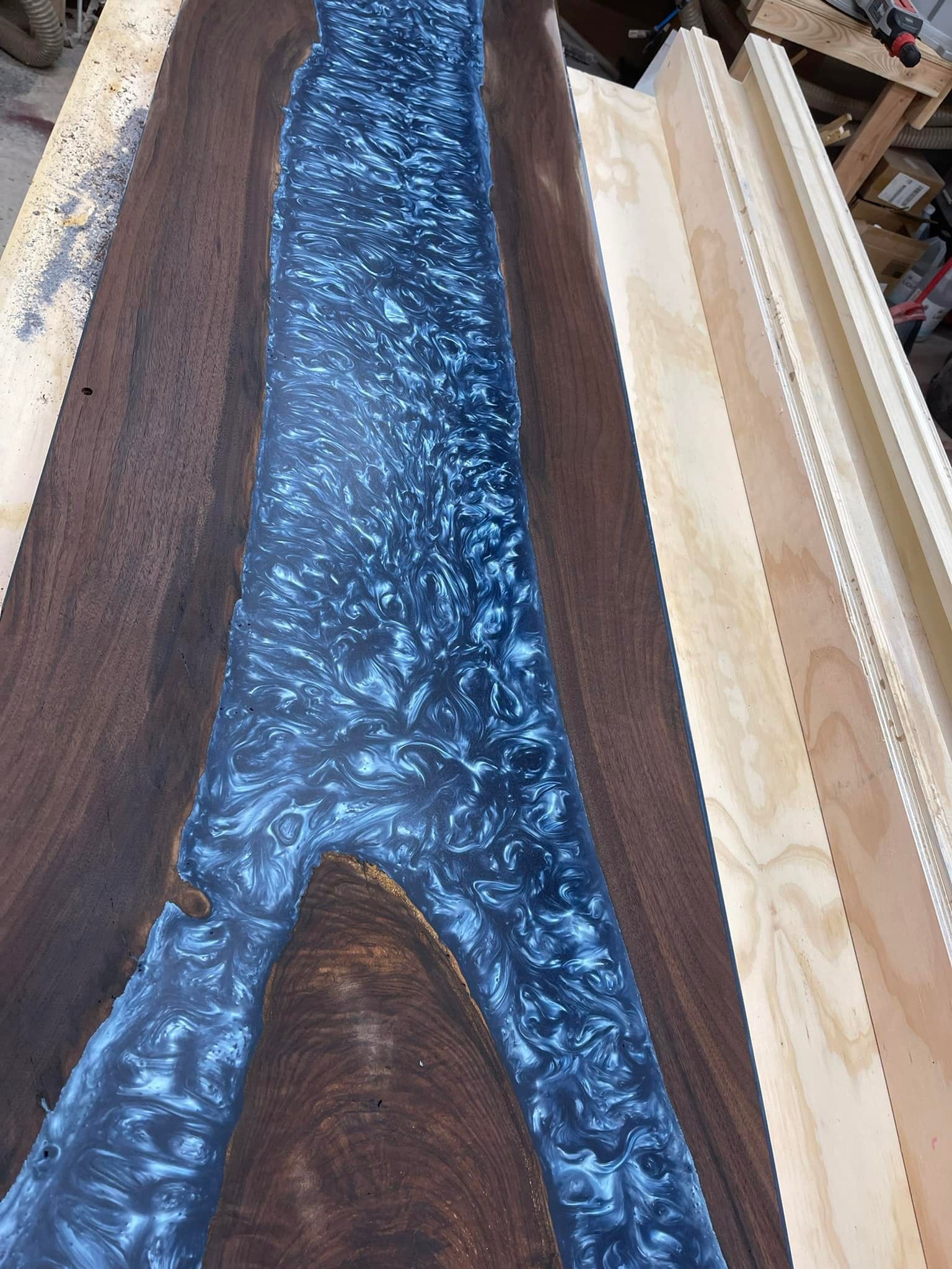 Wooden slab with blue resin river; woodworking project.
