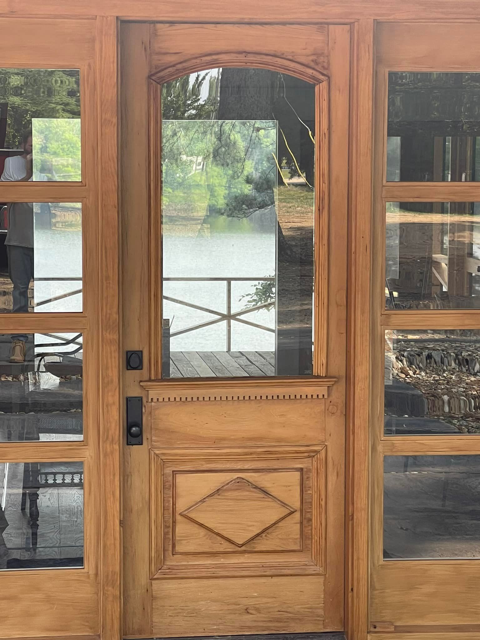Wooden door with glass panels and a view of a lake.