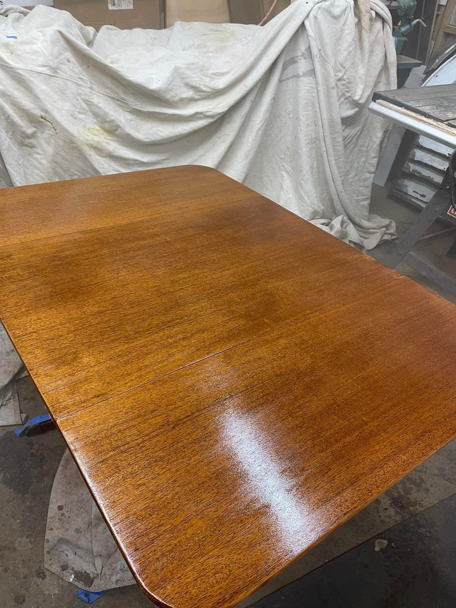 A wooden table with a mottled orange and brown finish. A white splash is present.