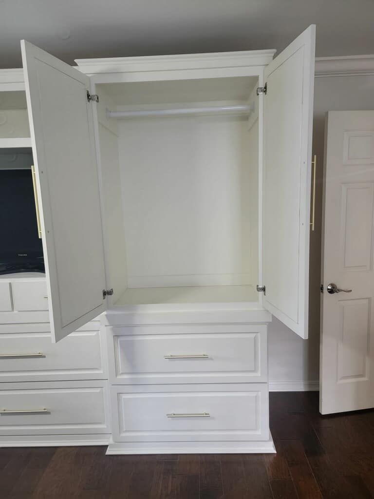 White closet with open doors, above two drawers, with a hanging rod.