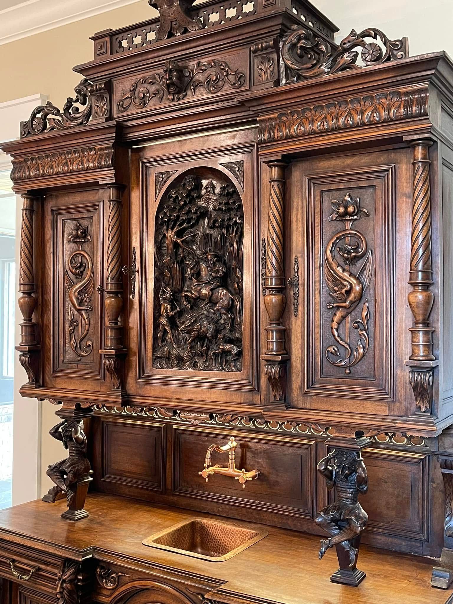 Ornate, wooden antique cabinet with intricate carvings, including a central, detailed relief.