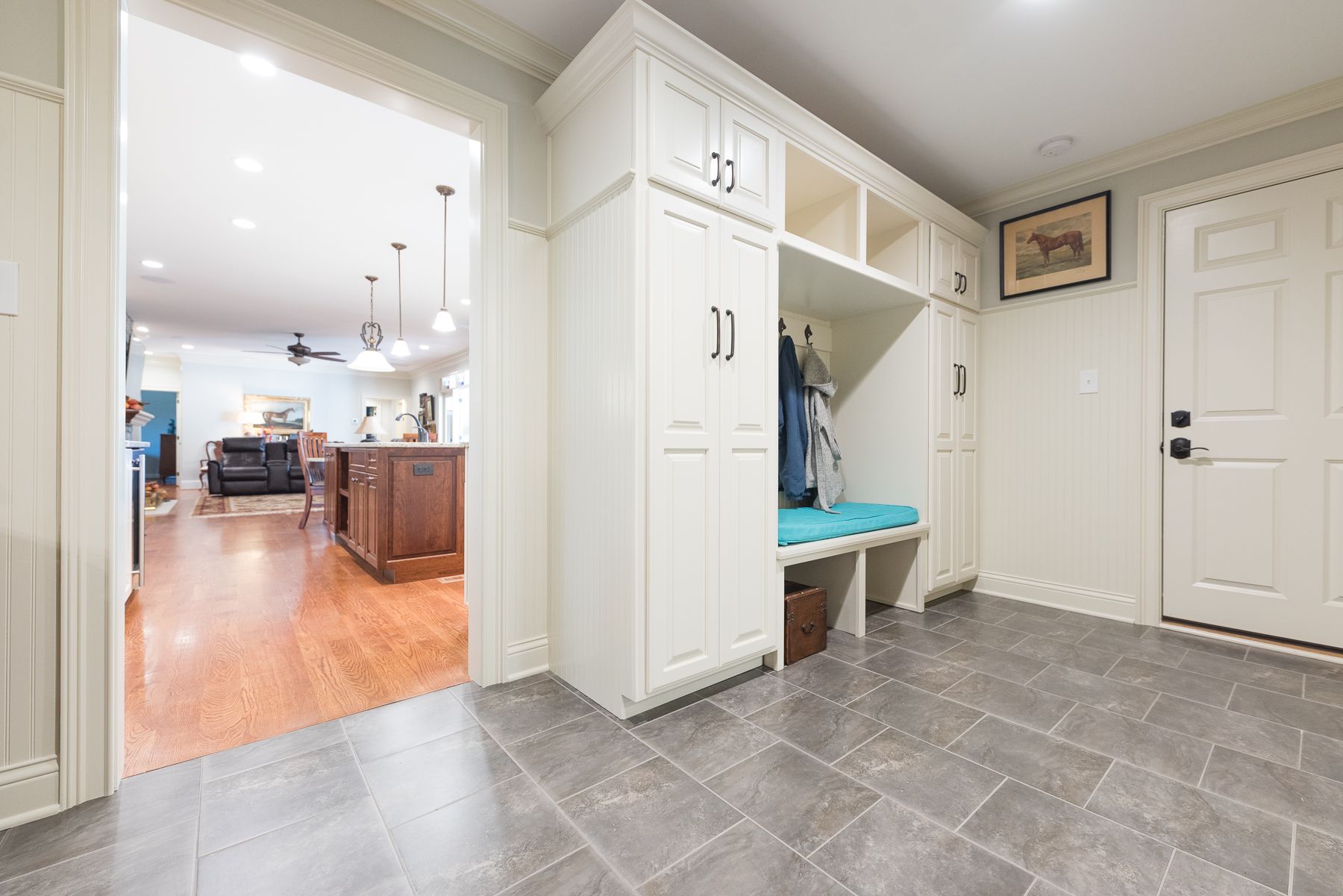 Mudroom with built-in storage, bench, and coat rack; leads to the kitchen.