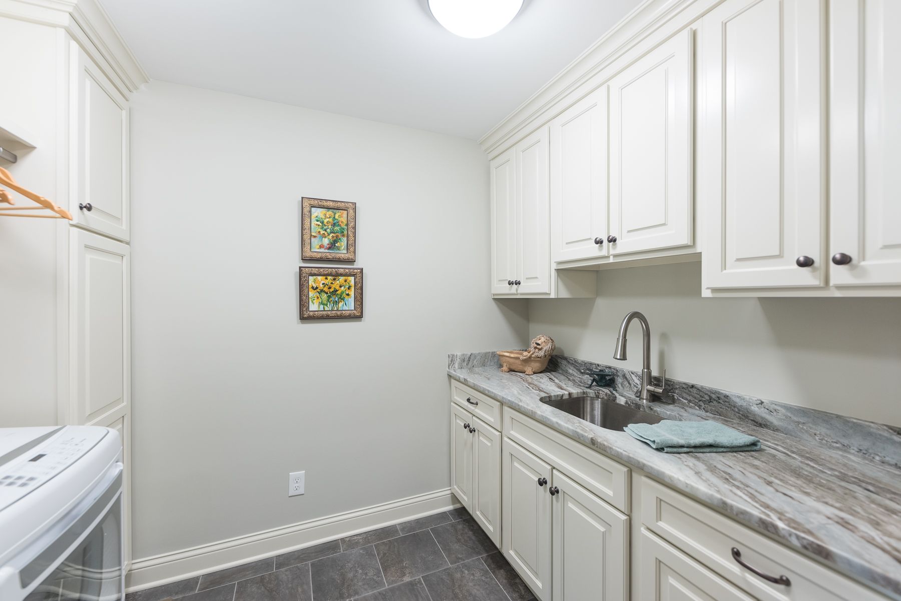 Laundry room with white cabinets, gray countertop, and washer/dryer.