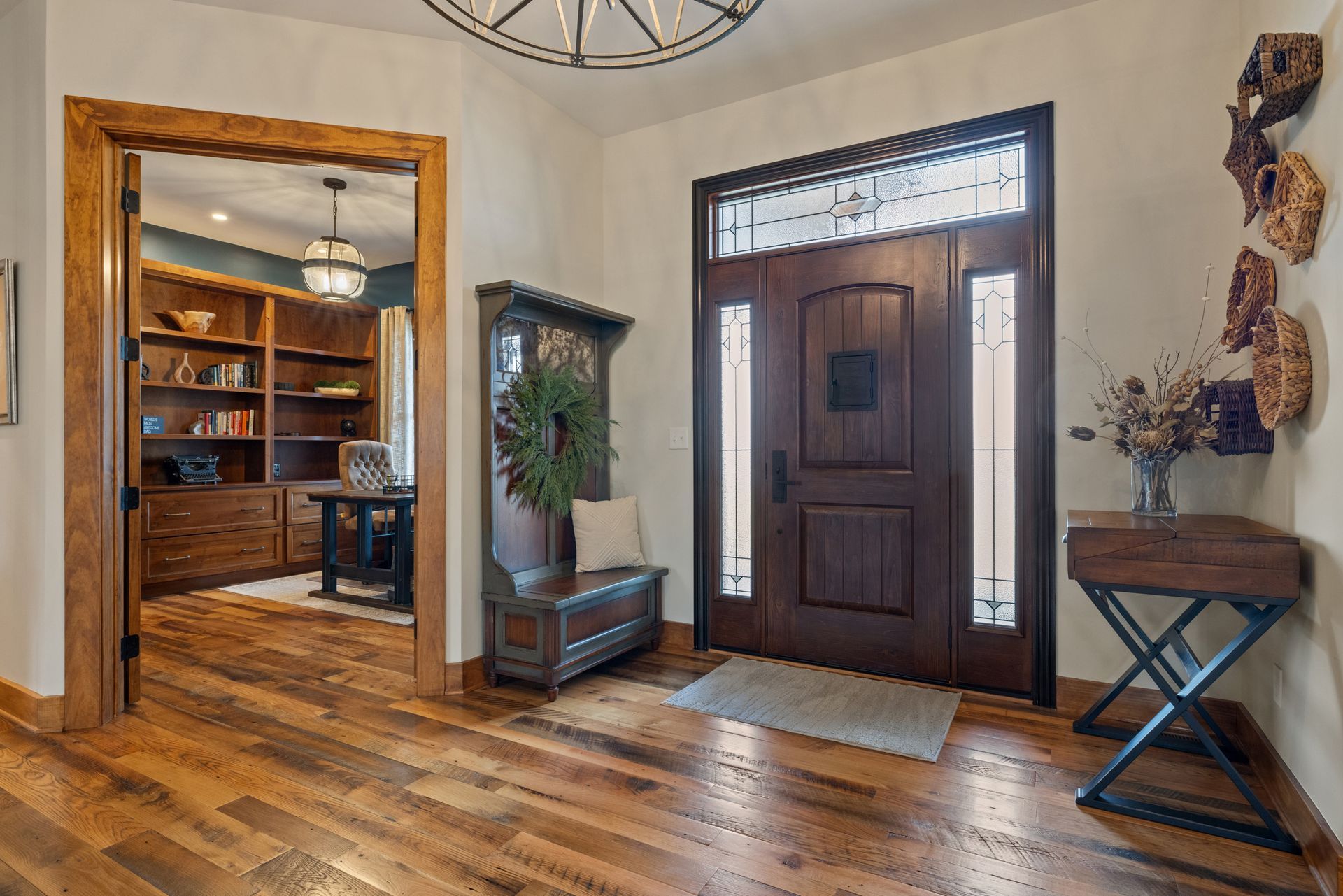 Wooden foyer with door, bench, and desk in a home.