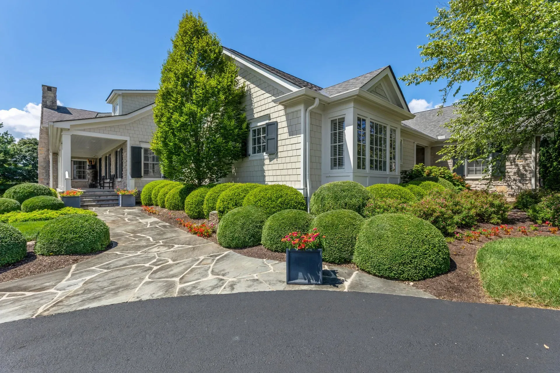 House with manicured landscaping and circular driveway.