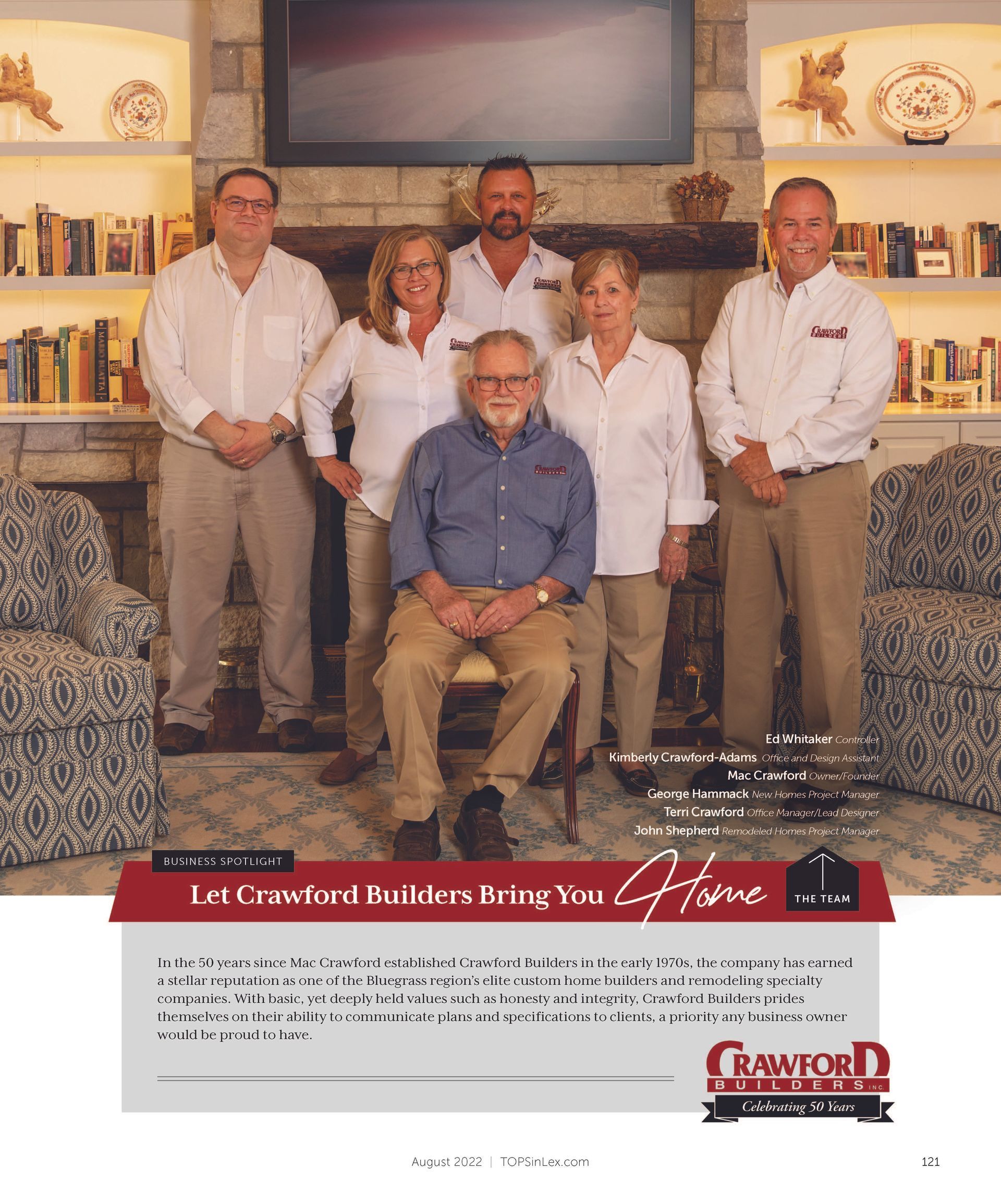 Family group portrait posing in front of fireplace with bookshelves. Man sitting in chair, others standing.
