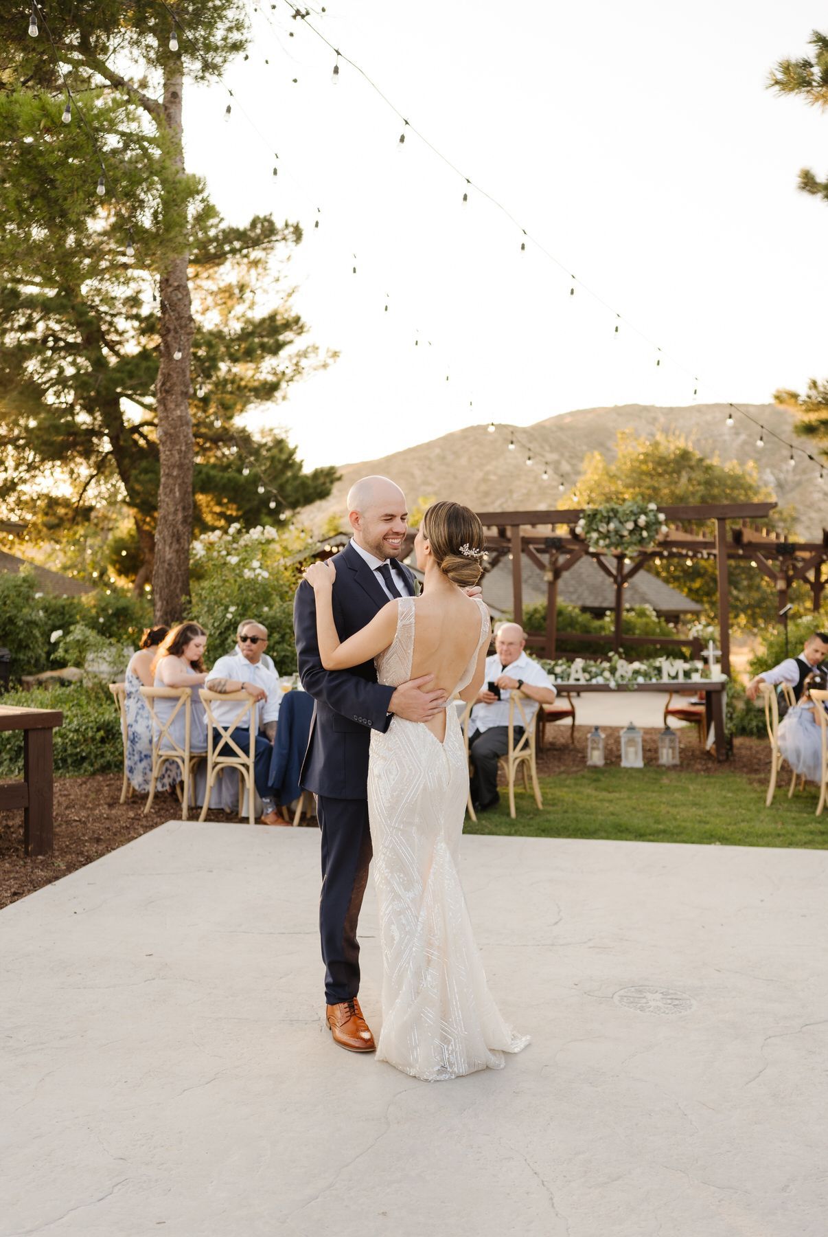 A bride and groom are dancing on an outdoor dance floor at their wedding reception in Oak Glen California.