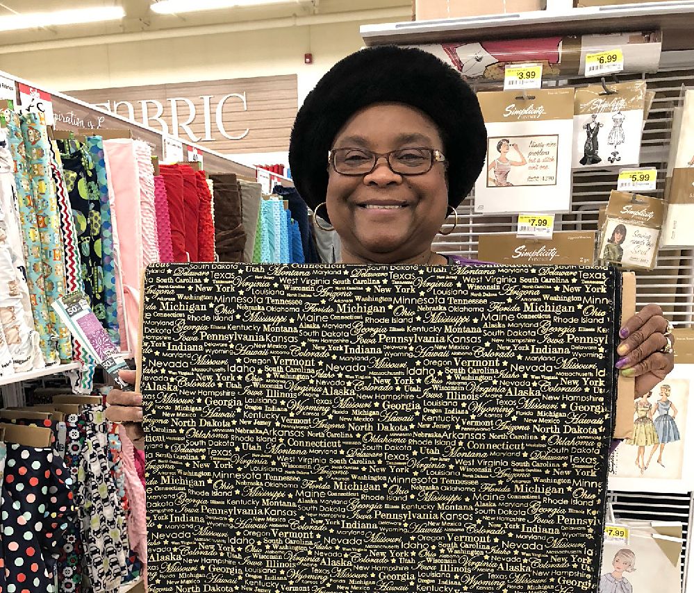 A woman is holding a piece of fabric in a store.