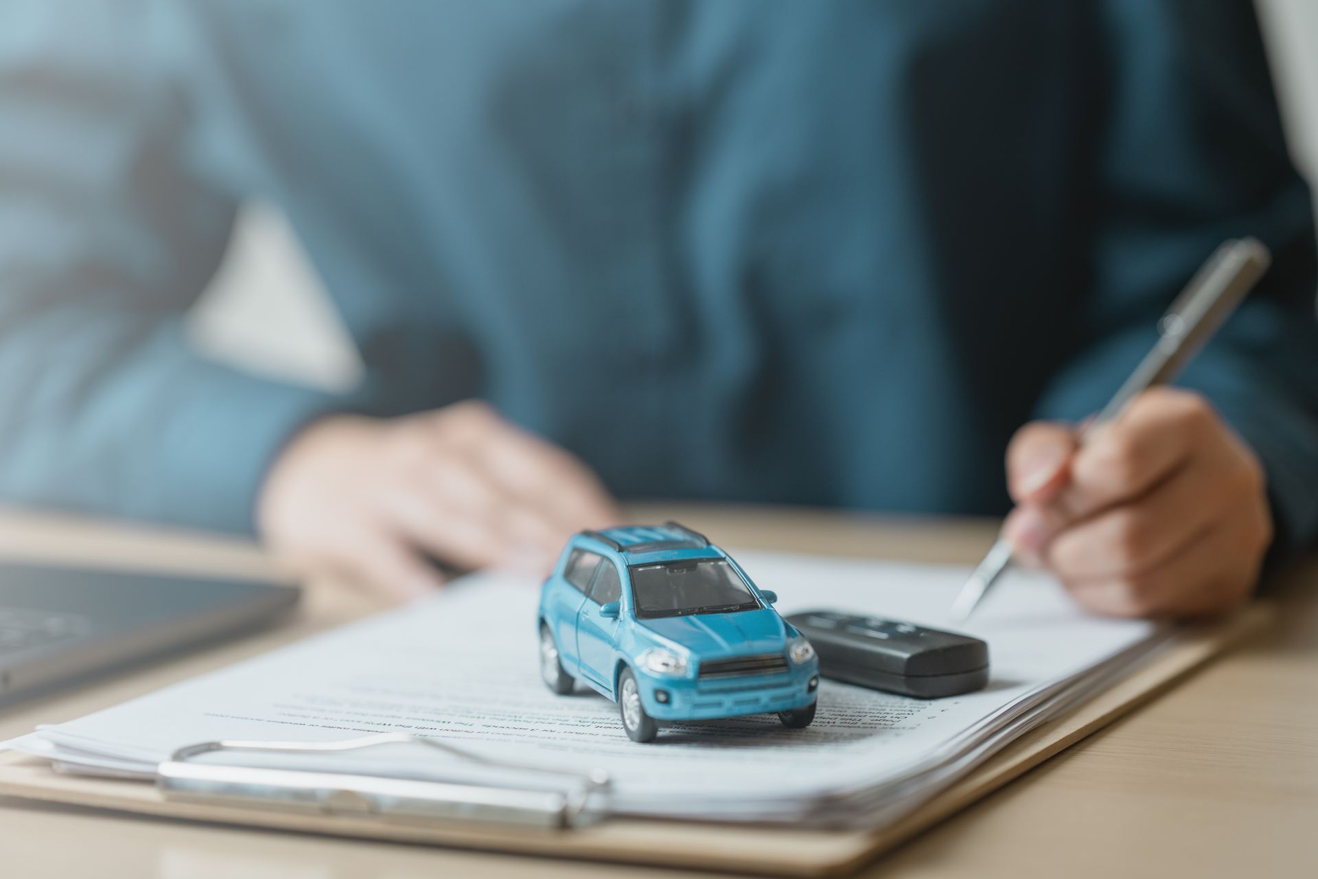 Handwriting notes beside a small blue toy car on an open notebook
