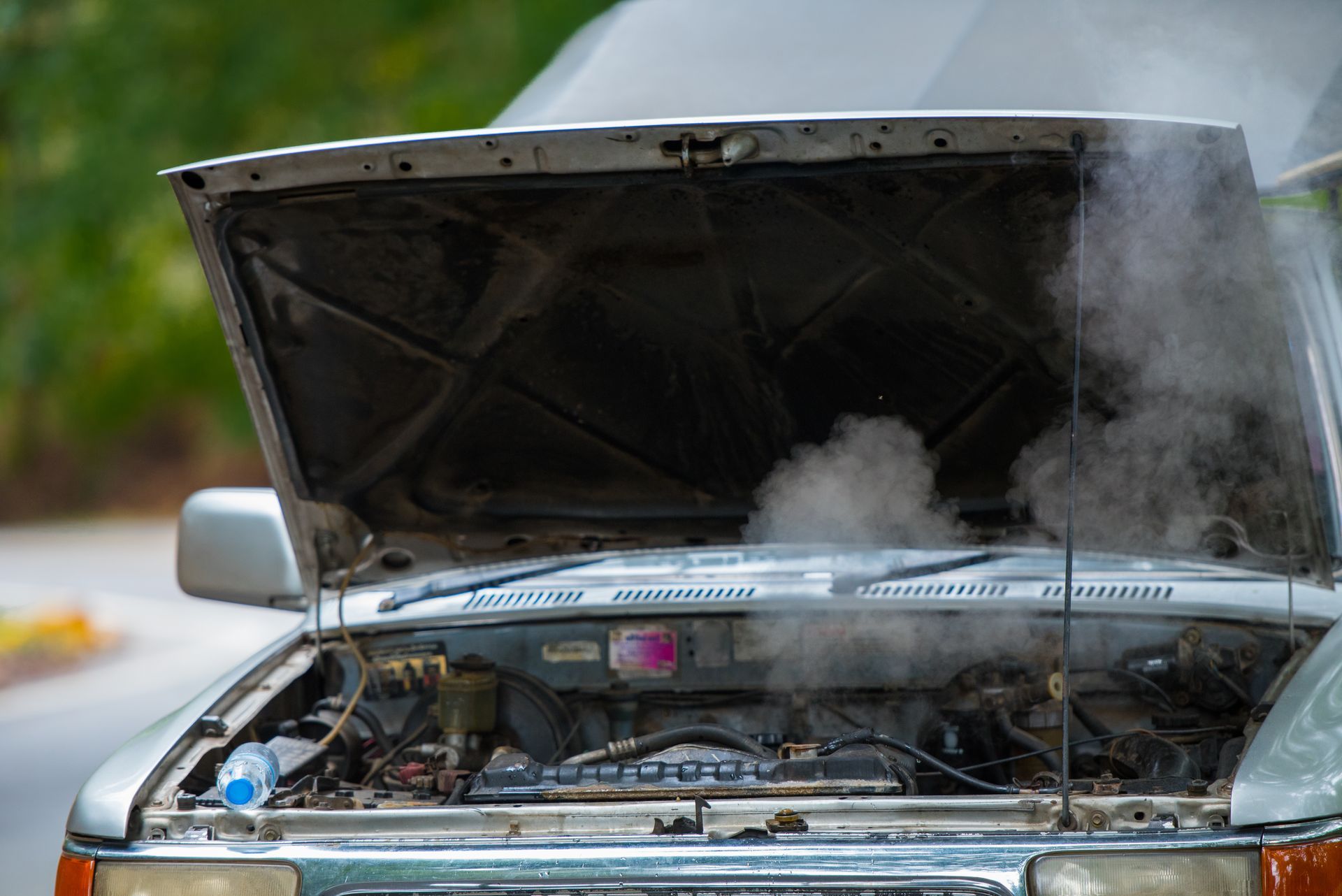 Car engine overheating with hood open and steam billowing out Car engine overheating with hood open and steam billowing out
