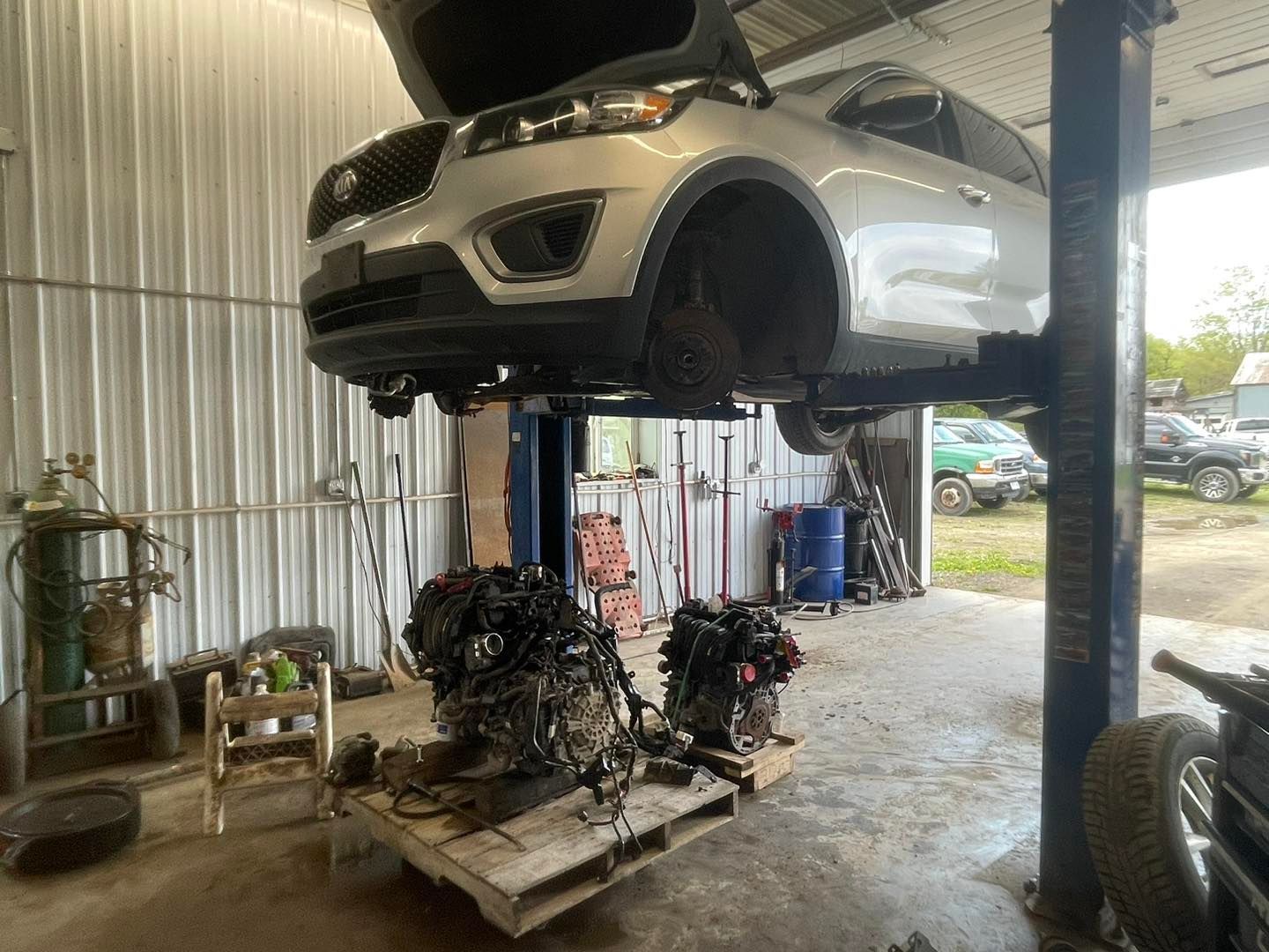A car is sitting on top of a pallet in a garage.