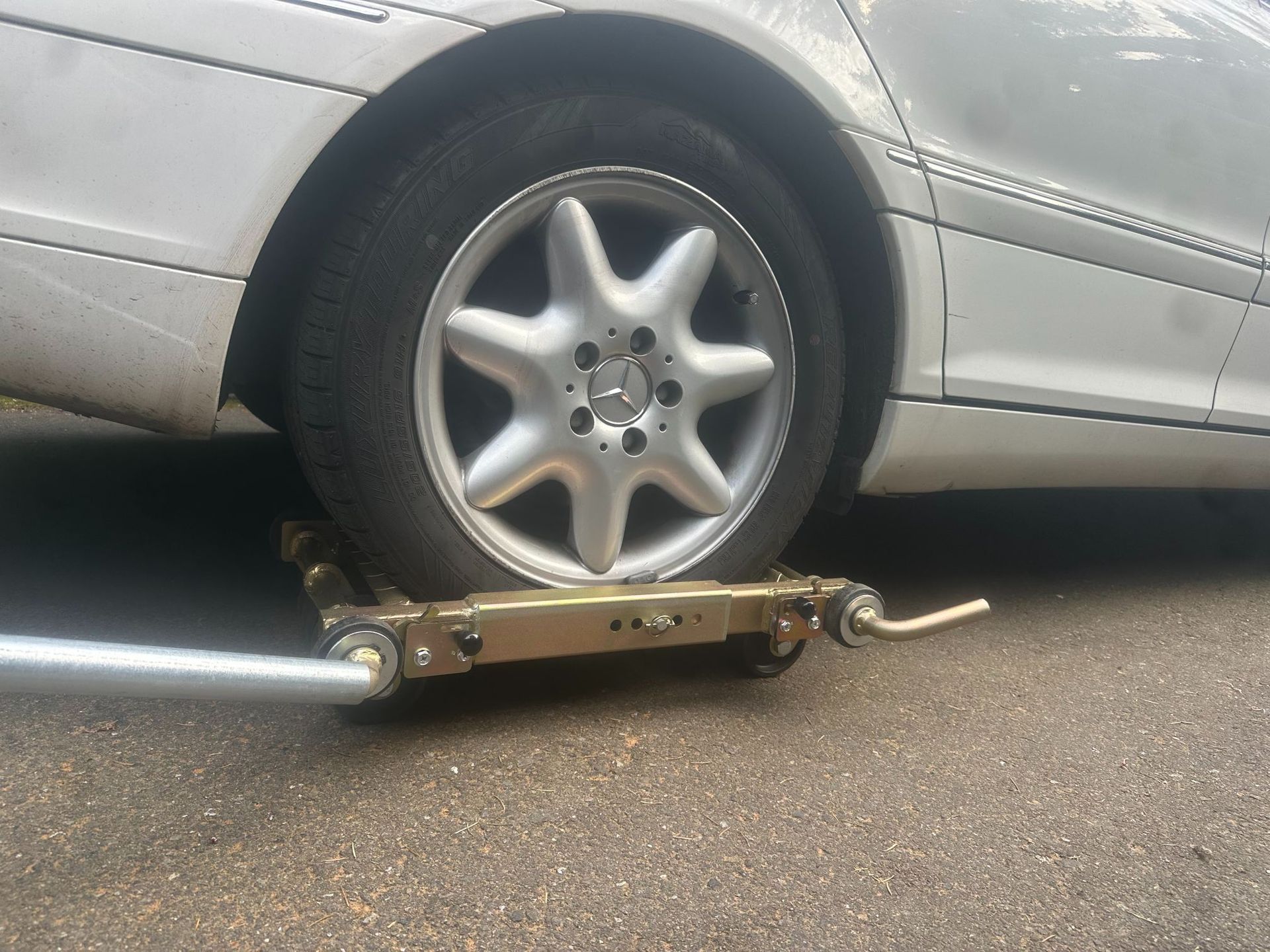 Car on a tow truck with the front wheel strapped down on the road