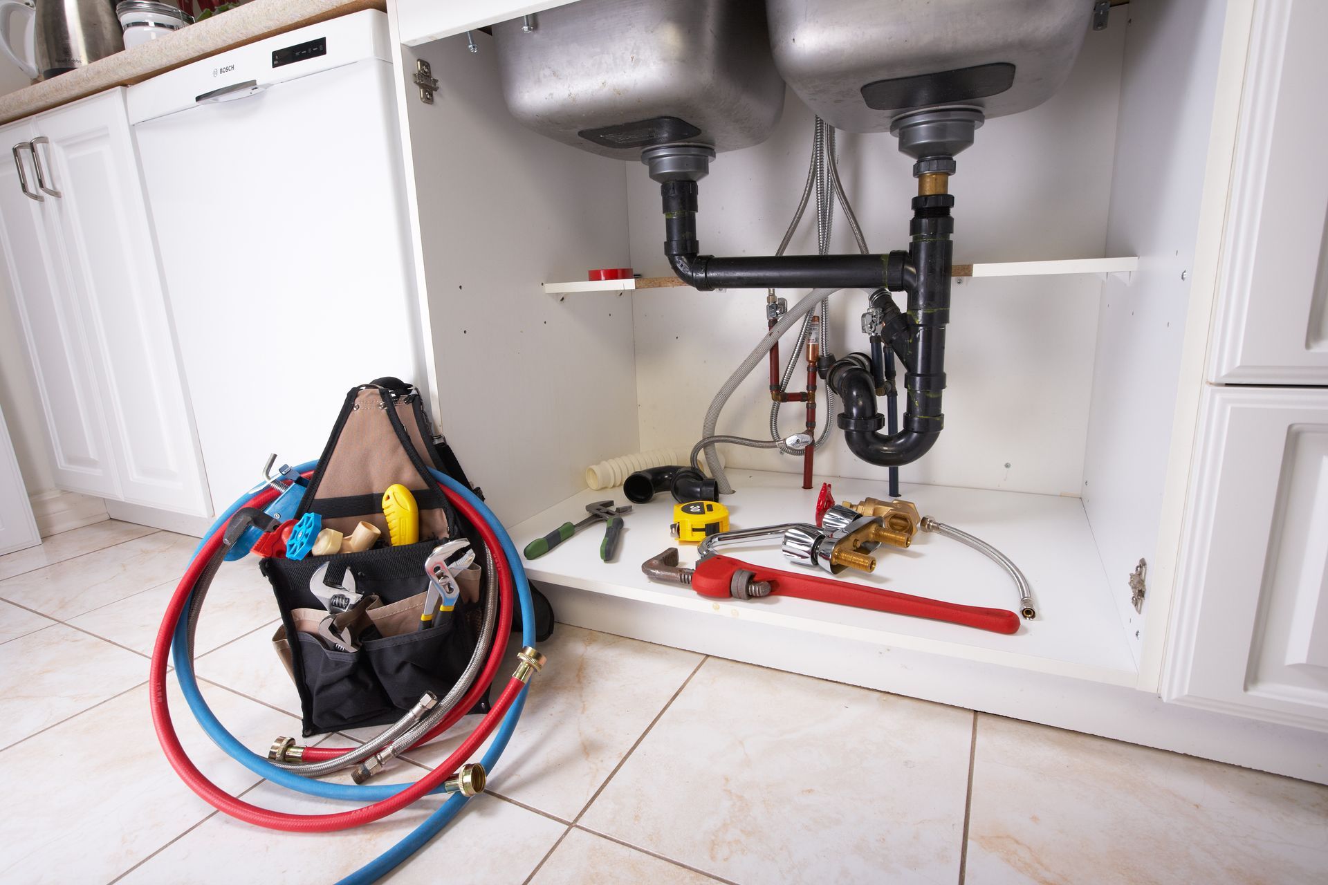 Worker in hard hat and gloves installing wall tiles in a bathroom corner.