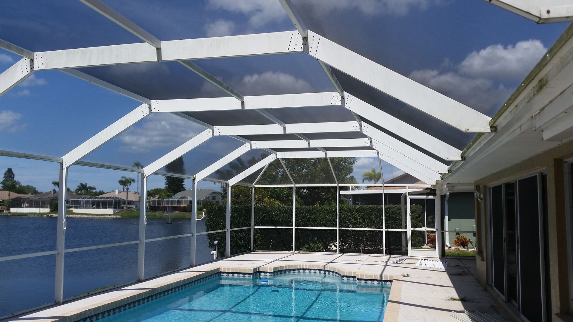 A screened in swimming pool with a view of a lake