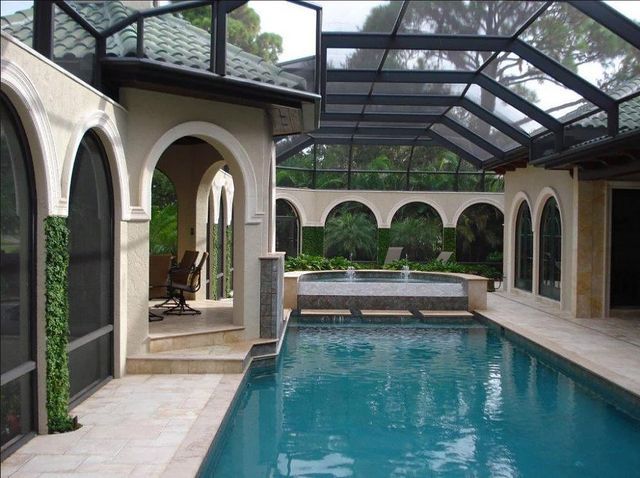 A large indoor swimming pool with a screened in area