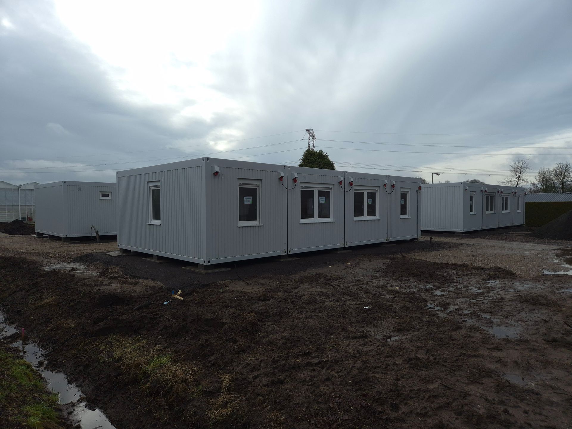 Een zeecontainer staat midden op een grasveld.