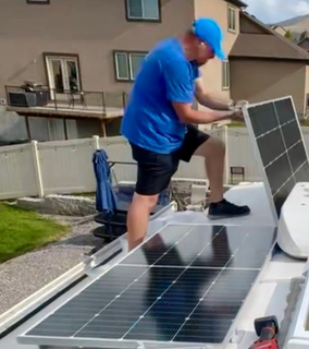 Camper with a mini solar module roof standing in the green meadow