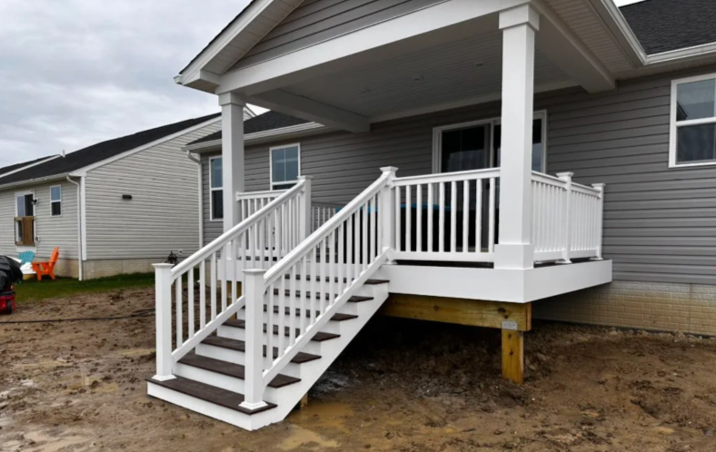 White front porch ramp and steps on a gray house under construction