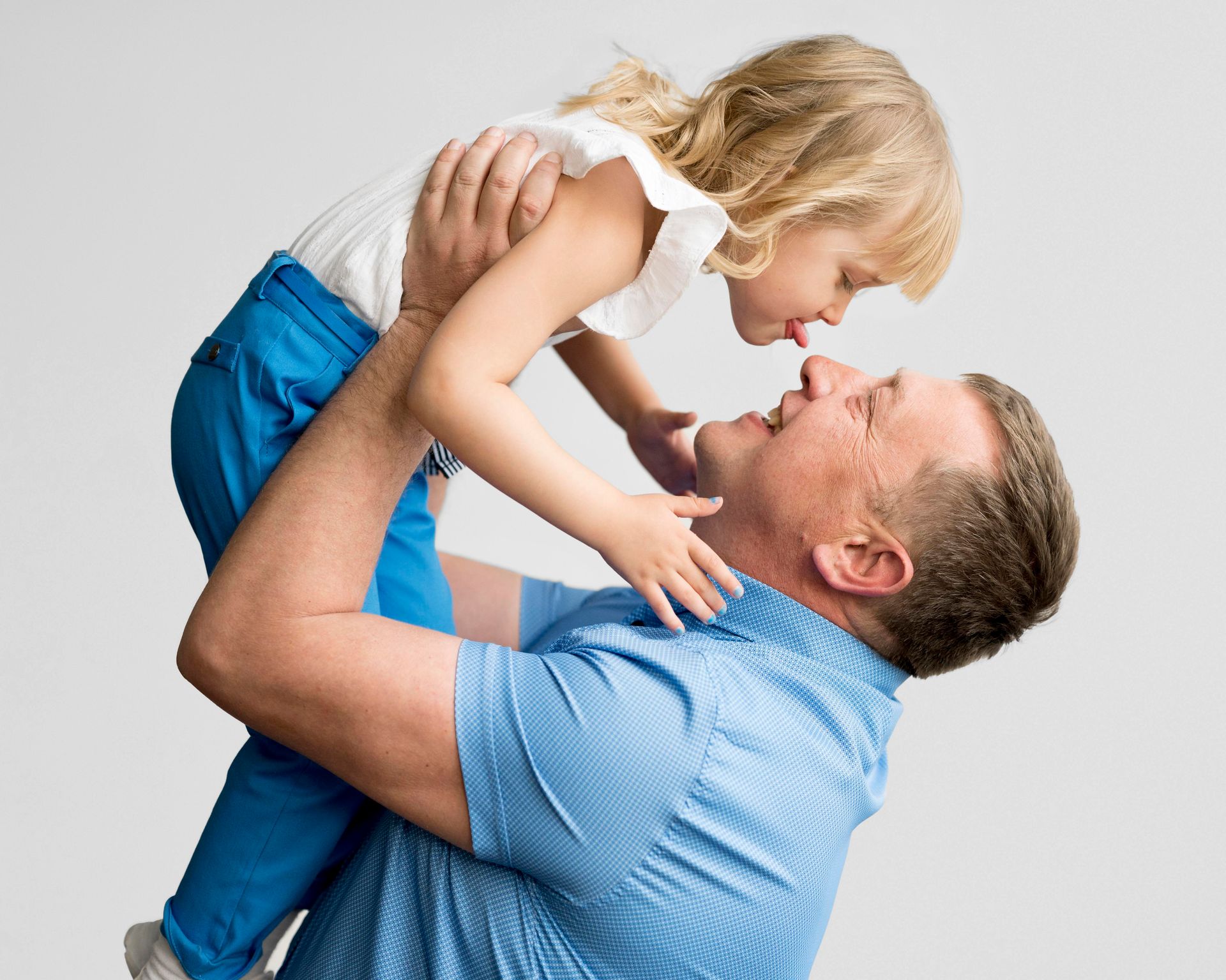 A man is holding a little girl in his arms.