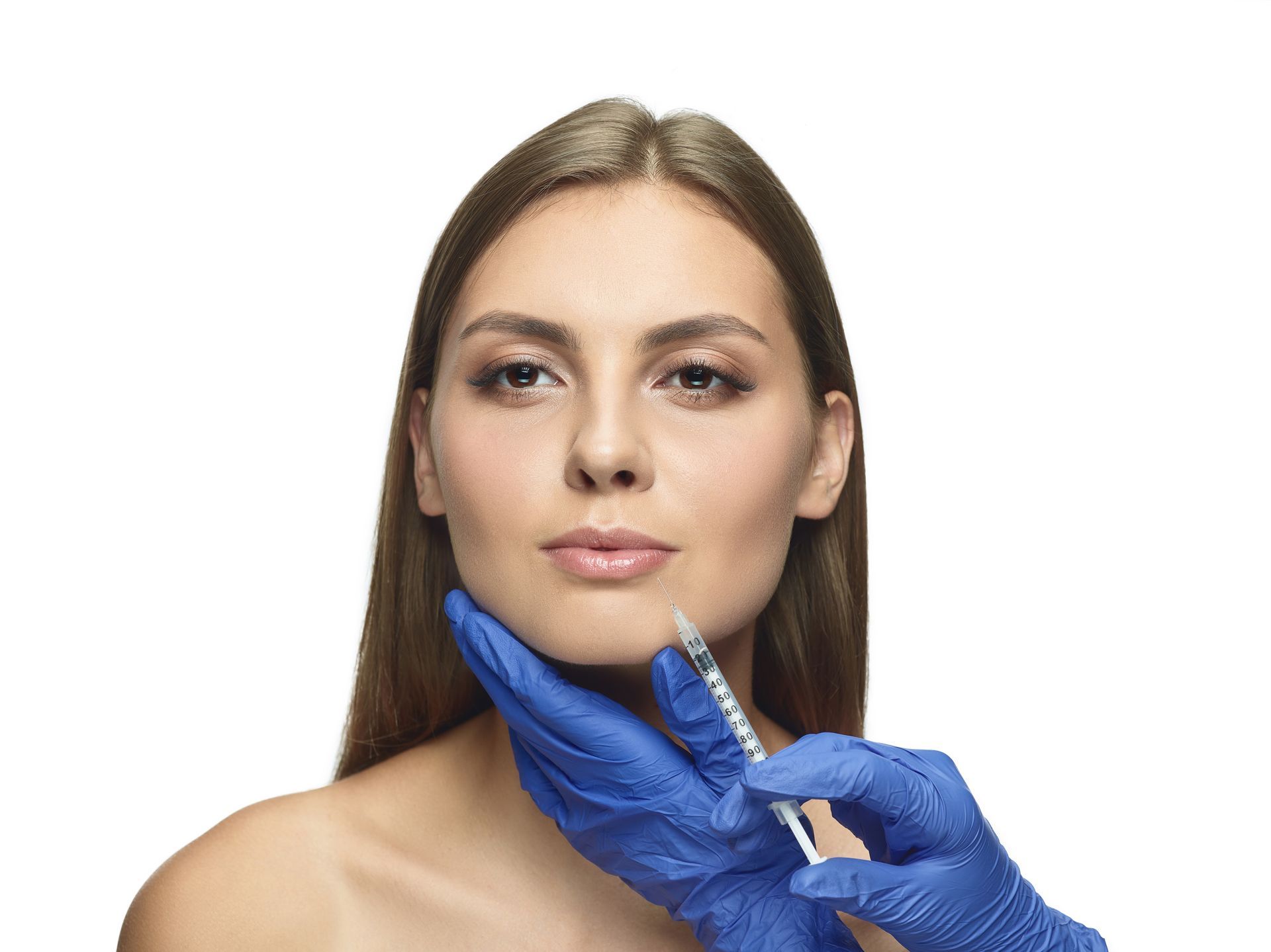 Woman receiving facial filler injection; doctor's gloved hand holds syringe to her cheek.