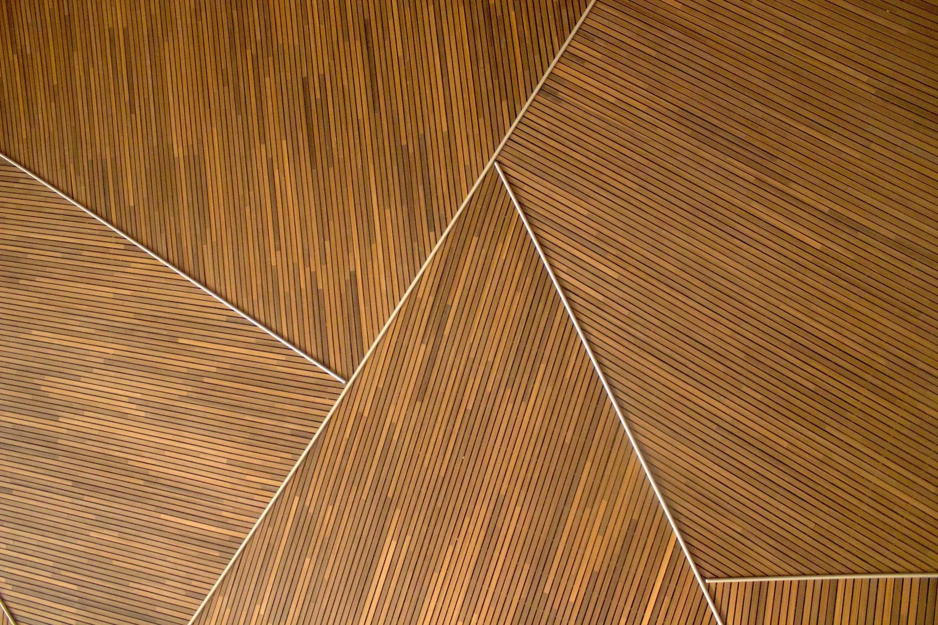 Geometric wooden panels in brown, with white seams dividing the sections, forming abstract shapes.