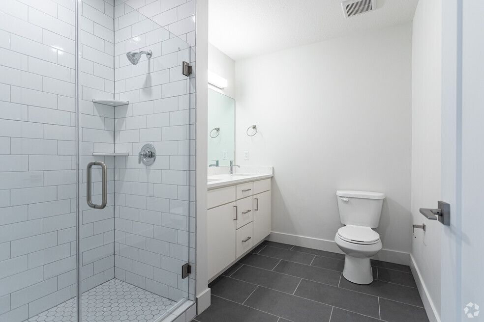a bathroom with a toilet , sink and shower .