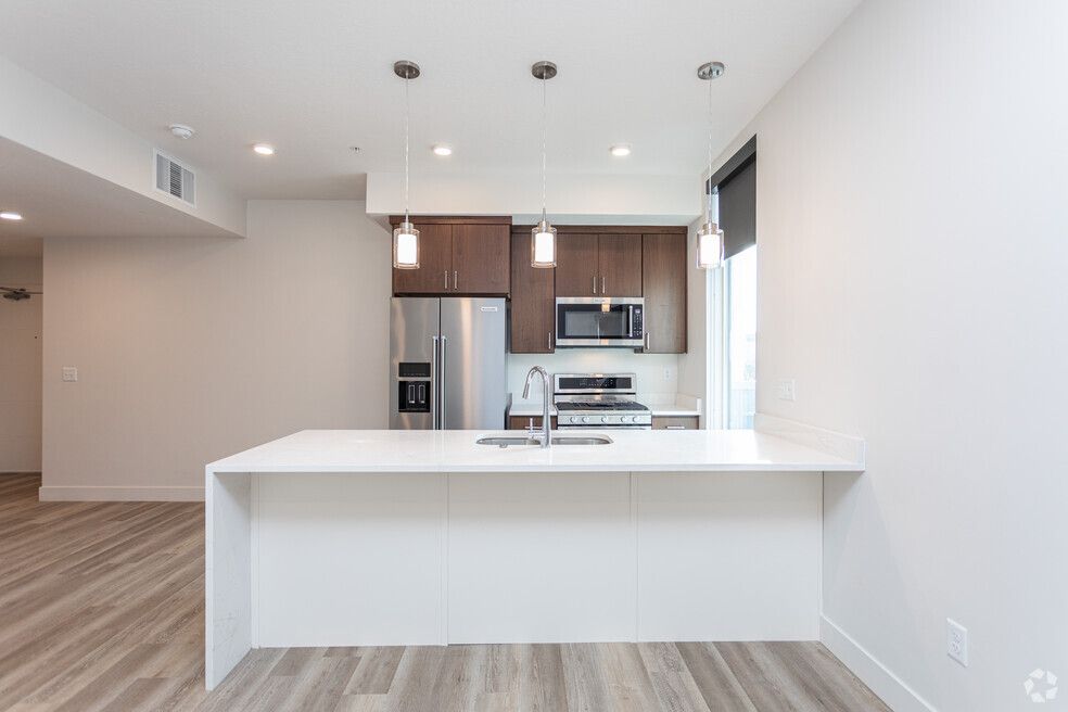 an empty kitchen with a large island and stainless steel appliances .