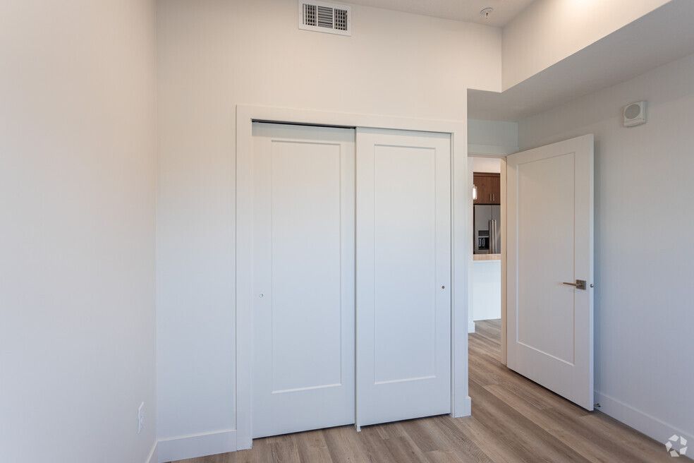 there is a closet in the middle of the room with sliding doors .