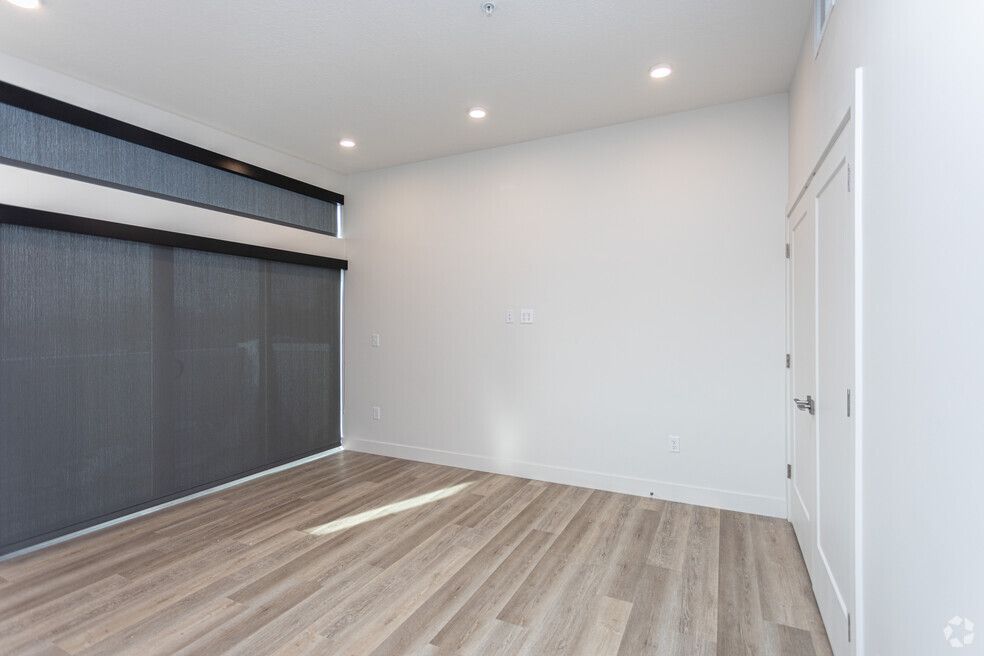 an empty room with hardwood floors and white walls .