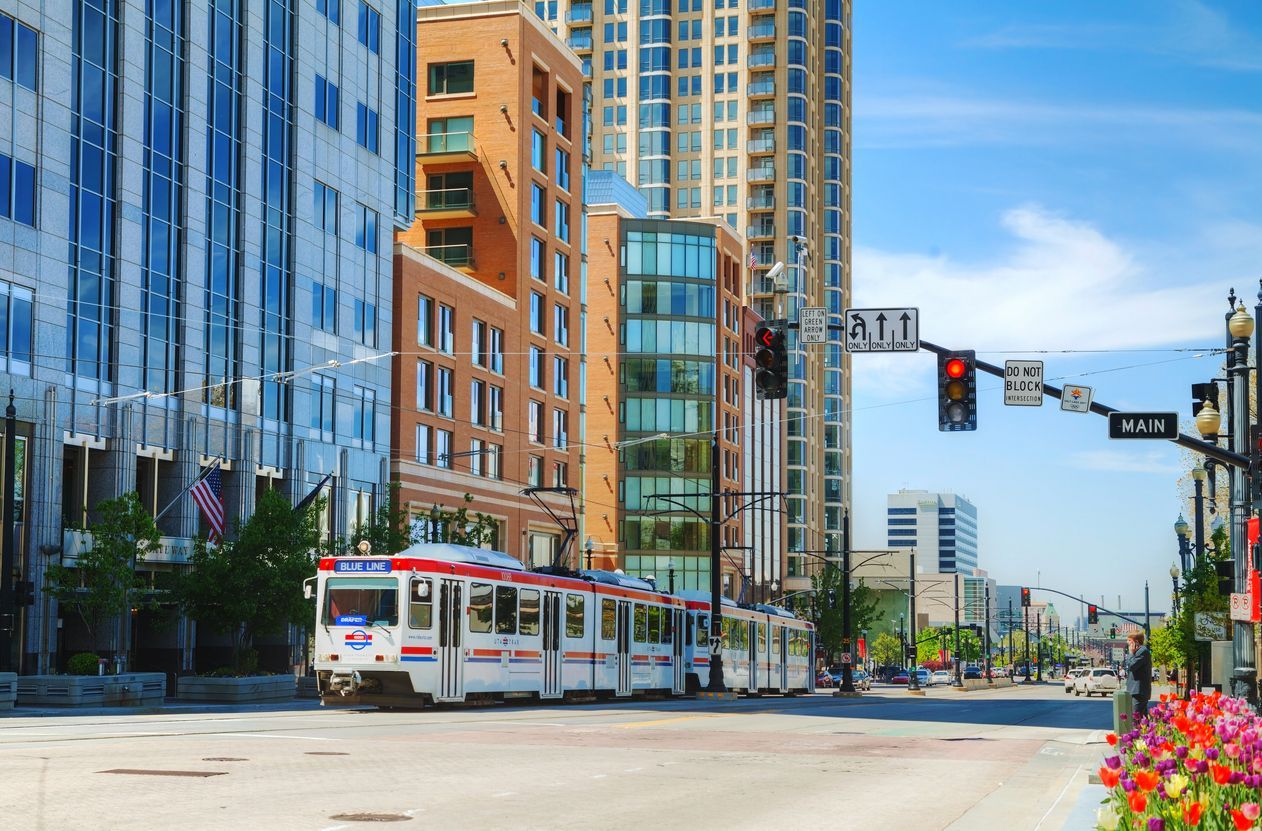 a trolley is driving down a city street . - Click to go to contact us page 
