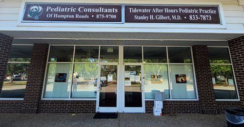 Exterior of a medical office: Pediatric Consultants, Tidewater After Hours Pediatrics Practice. Glass doors, brick facade.