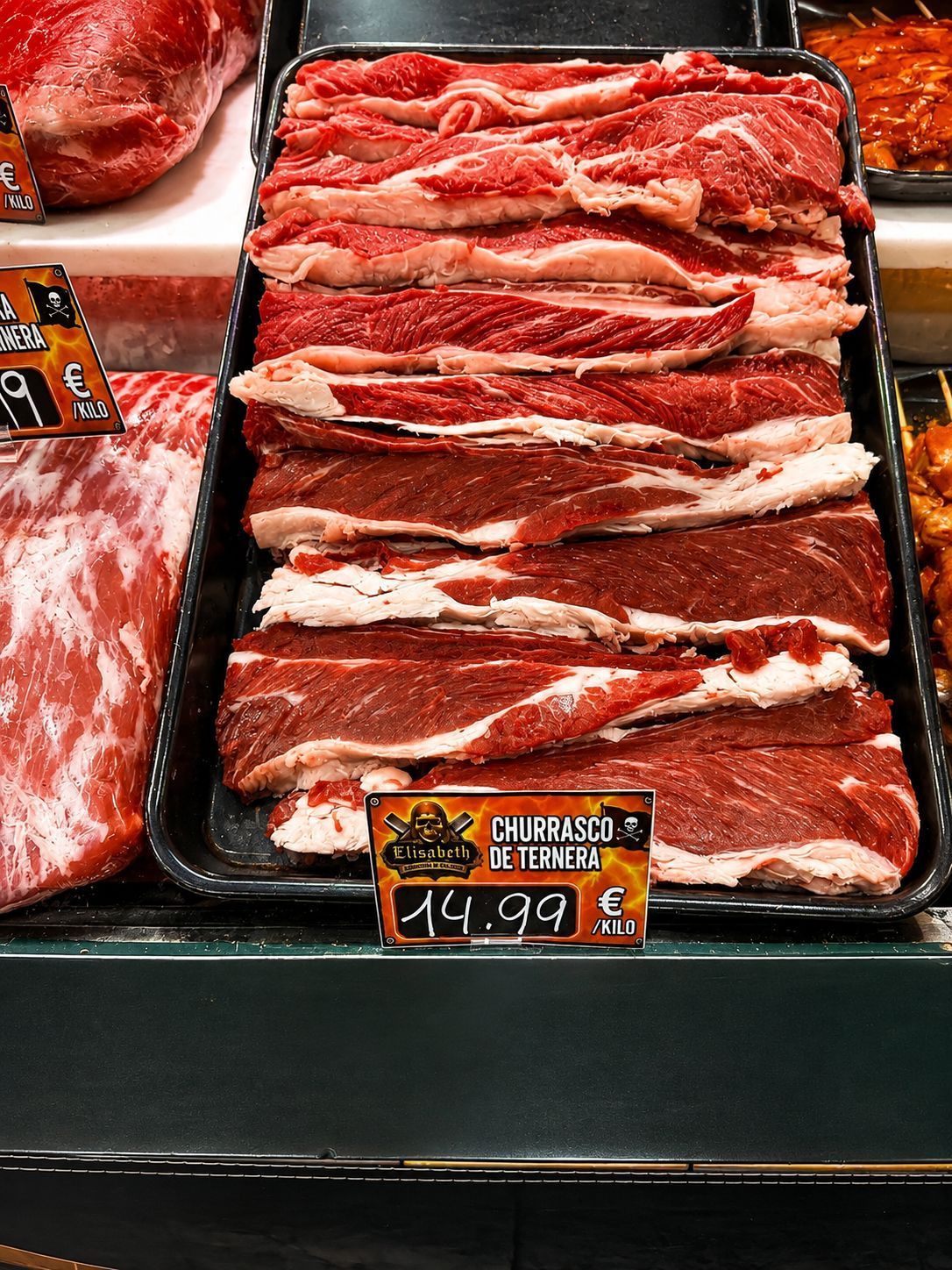 Bandeja de lonchas de carne cruda en un expositor de mercado, con etiqueta de precio.