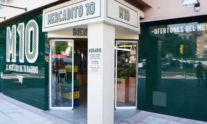 Local comercial en esquina con ventanas de cristal verde y un letrero blanco que dice 