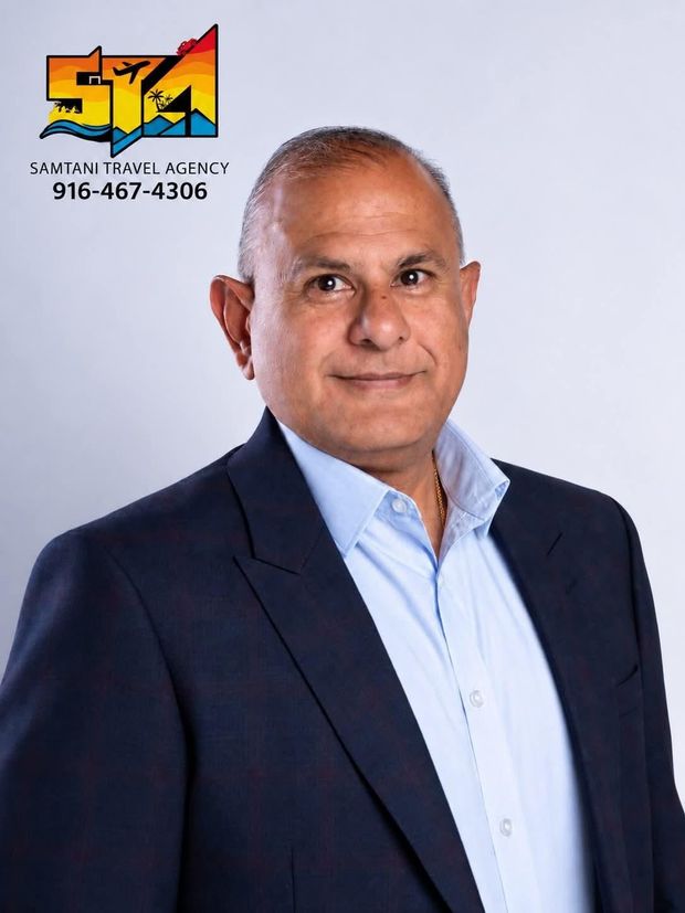 A man in a vest and tie is smiling for the camera