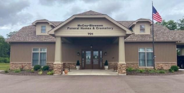 Front entrance of a community building with an American flag and stone facade.