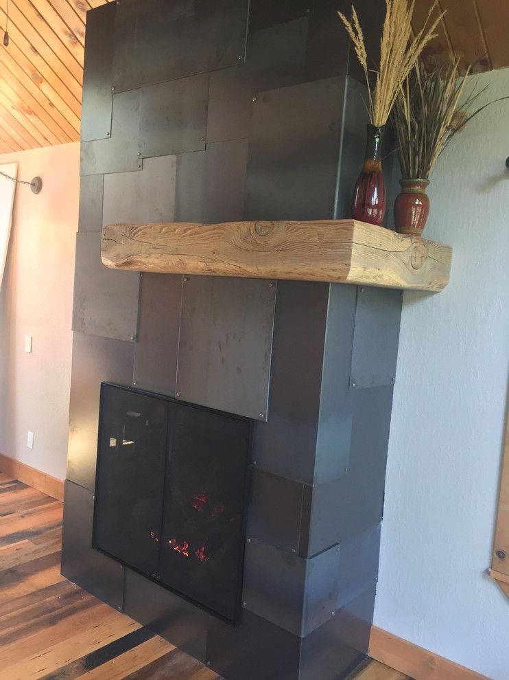 Fireplace with dark tiled facade, wooden mantel, and decorative vases.