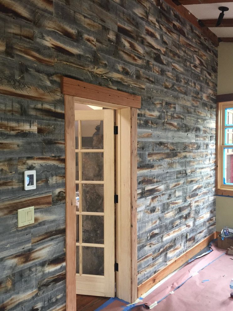 Wood-paneled wall with a doorway and window. Rustic look, various shades of gray and brown.