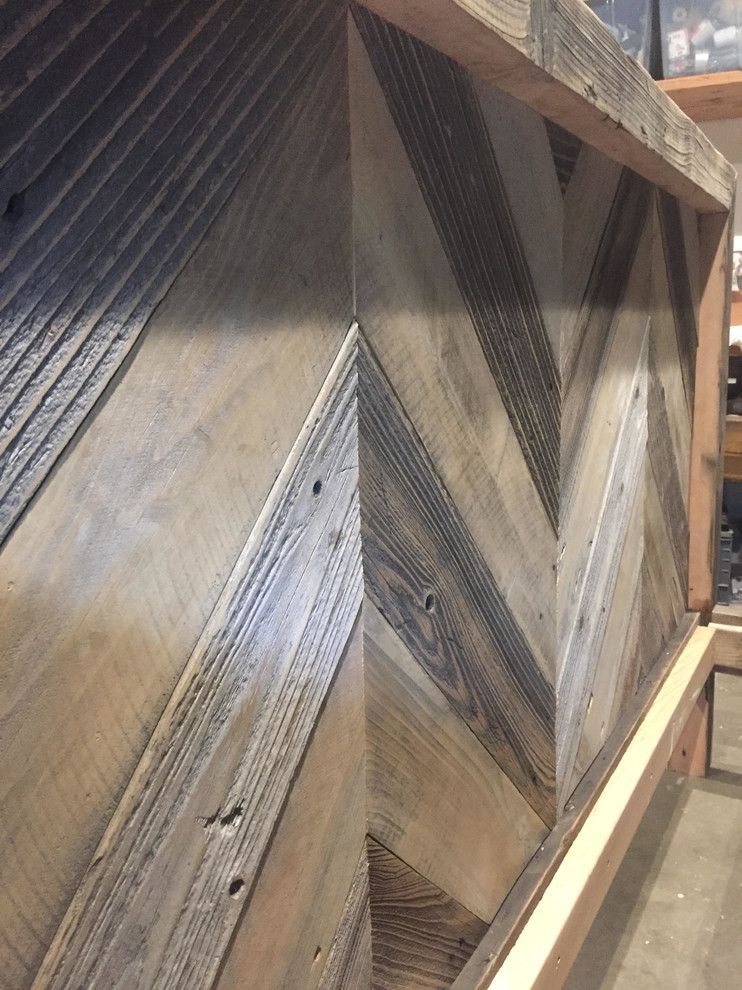 Wooden wall with a chevron pattern, constructed with weathered wood planks.