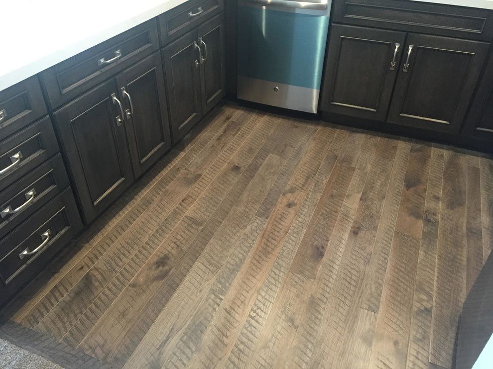 Kitchen with dark cabinets, white countertops, stainless steel dishwasher, and wood-look flooring.