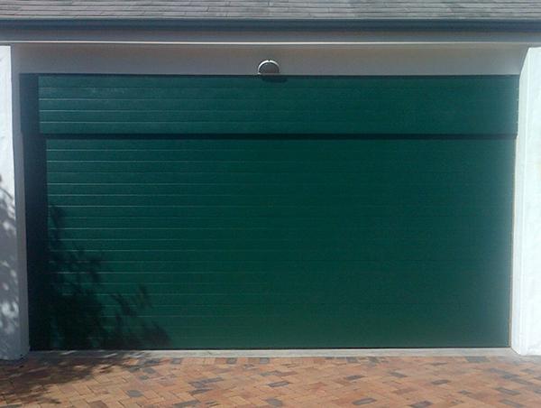 Green garage door in a white frame.