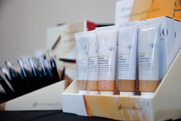 White cosmetic tubes and makeup brushes arranged in store display boxes