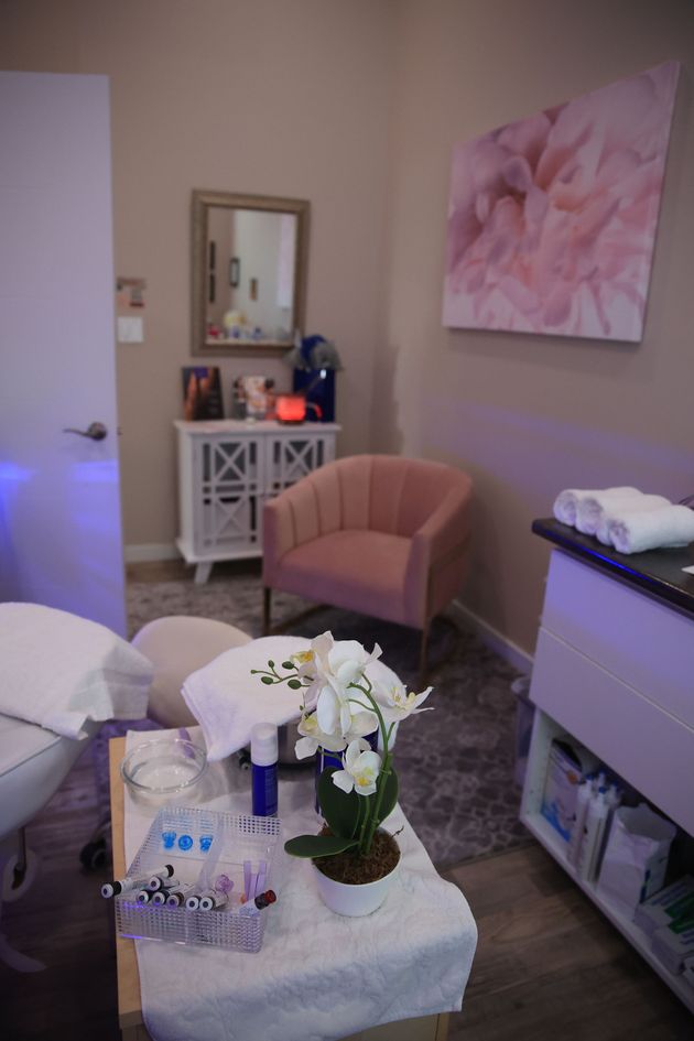 Cozy room with pink chair, white coffee table, floor lamp, dresser, and floral wall art